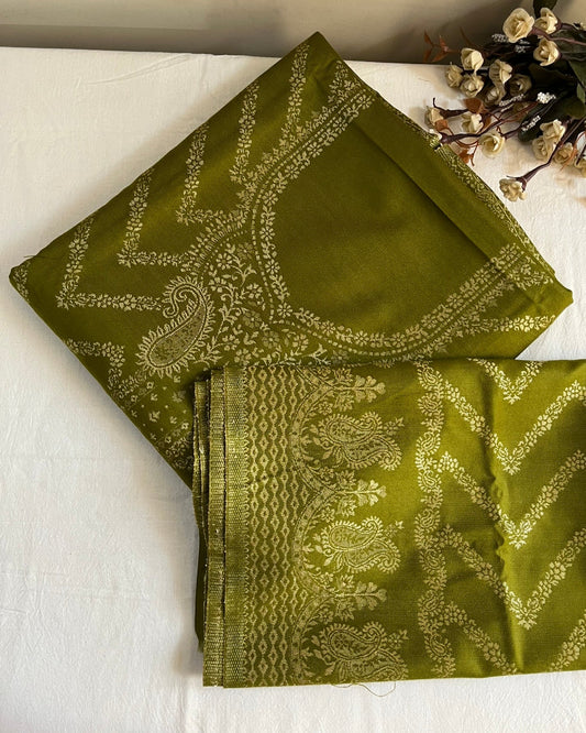 Green fabric with intricate patterns on a white surface